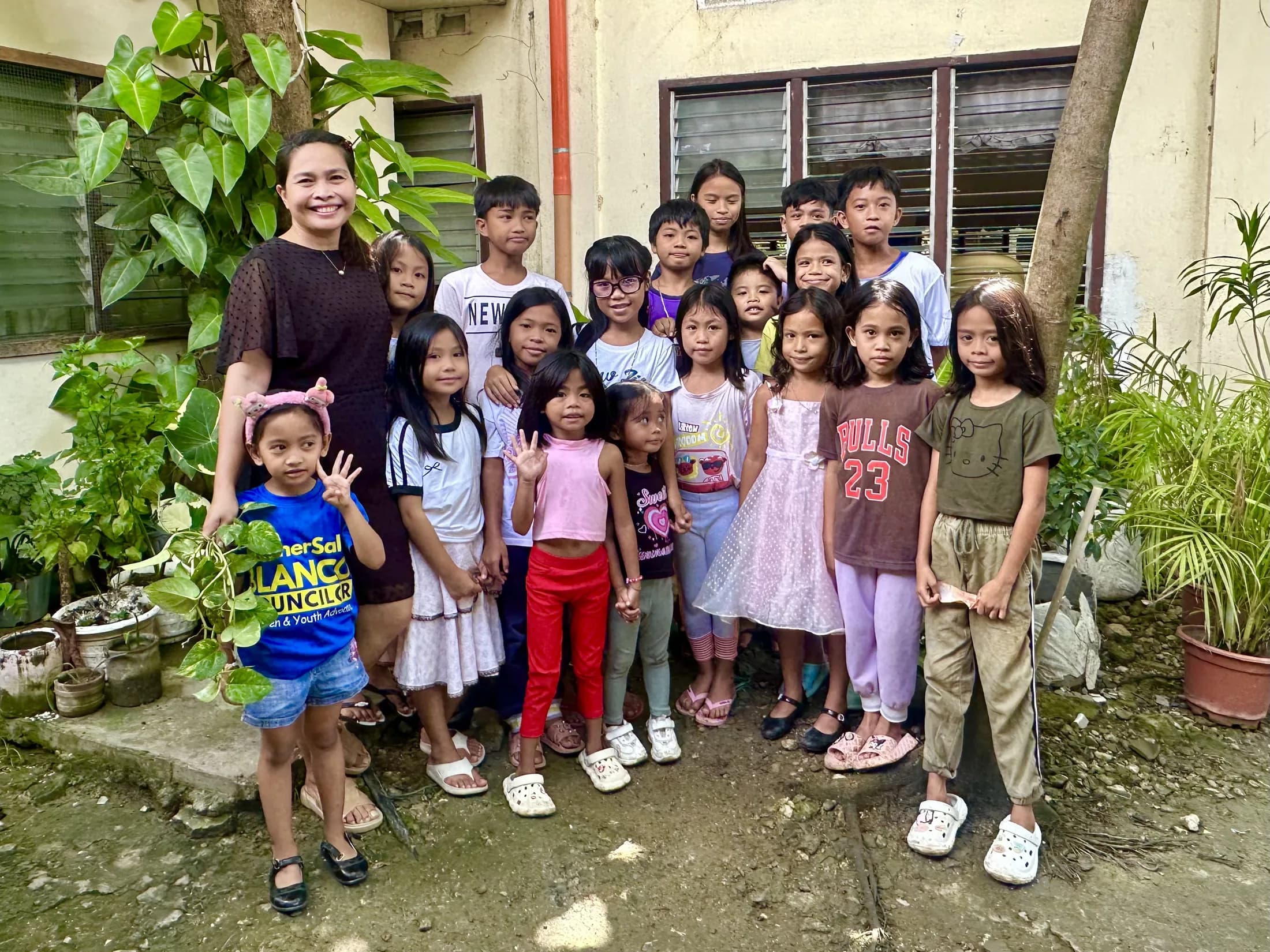 A woman standing with children outside a home