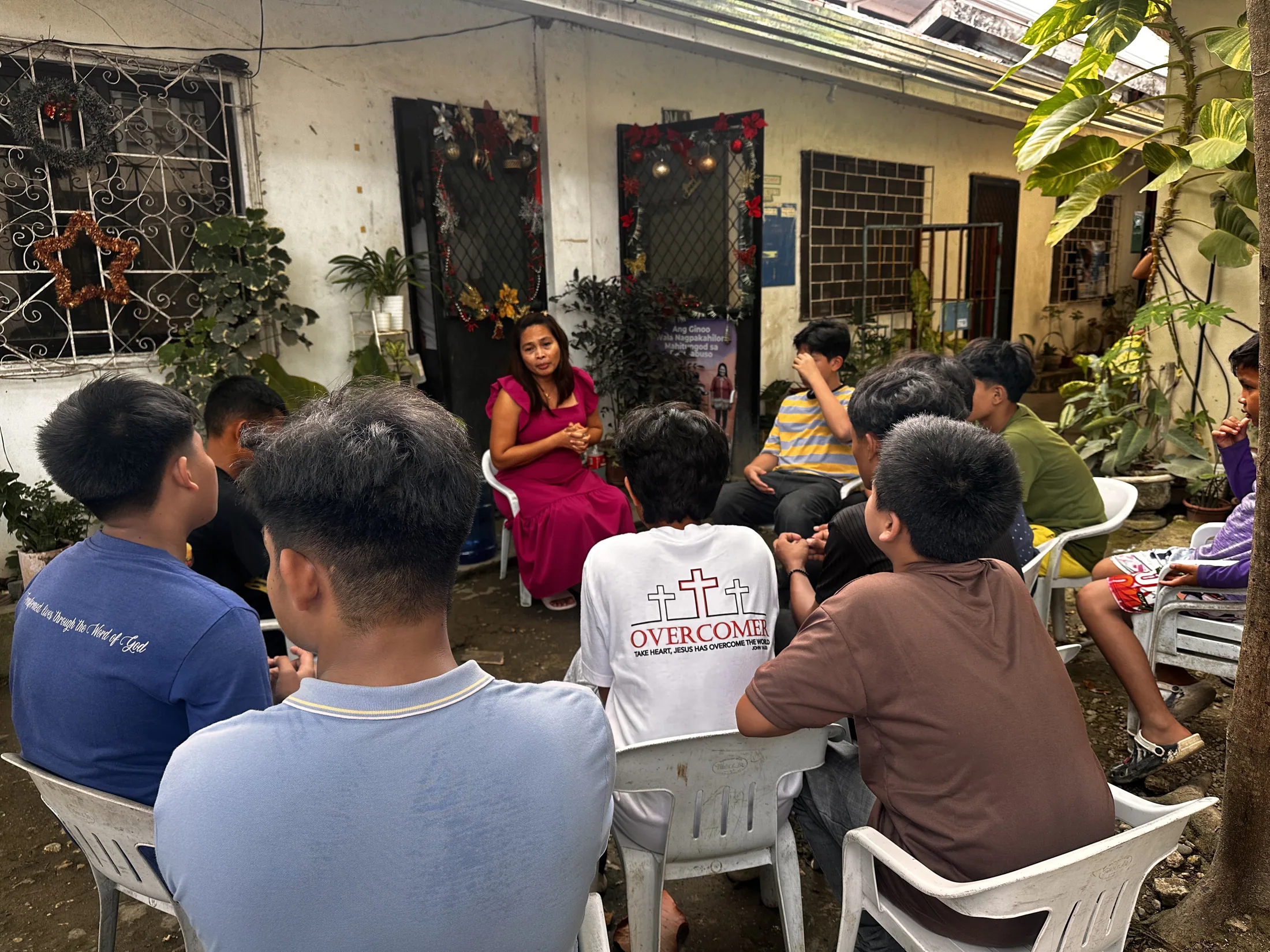 Children and adults seated together in a small group outdoors